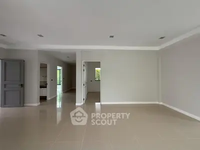 Spacious open-plan living area with tiled flooring and neutral walls, perfect for customization.