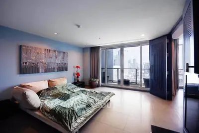 Luxurious bedroom with stunning city view and modern decor in high-rise apartment.