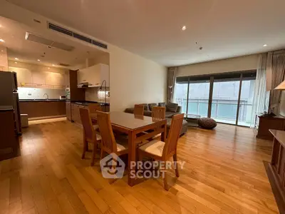Spacious open-plan living and dining area with wooden flooring and modern kitchen.