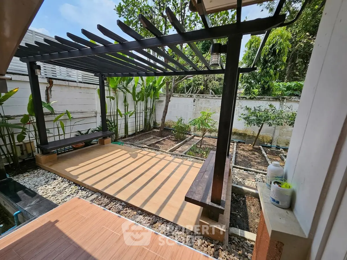 Charming garden with pergola and lush greenery, perfect for outdoor relaxation.