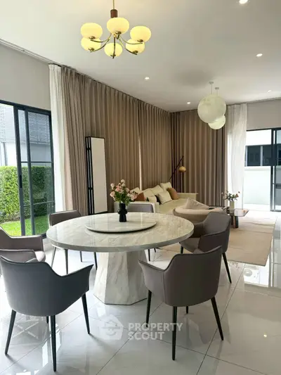 Elegant modern living room with marble dining table and stylish chairs, featuring floor-to-ceiling windows.