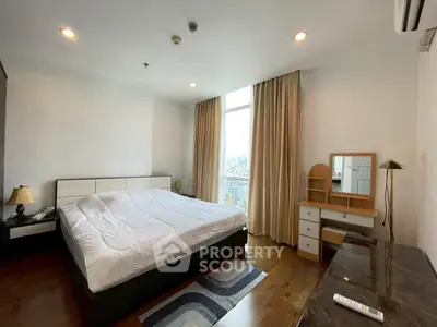 Spacious bedroom with city view, featuring a large bed, wooden flooring, and elegant curtains.