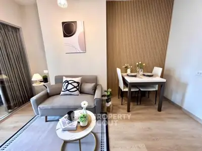 Modern living room with stylish decor and dining area, featuring a cozy armchair and elegant table setting.