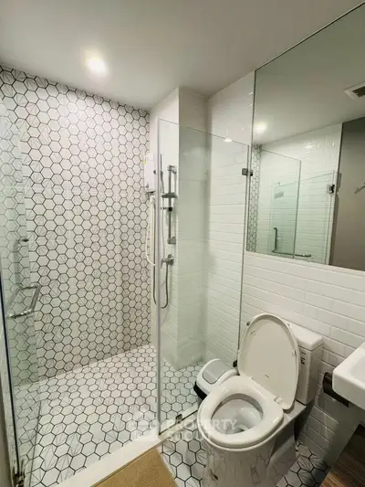 Modern bathroom with glass shower and stylish hexagonal tiles