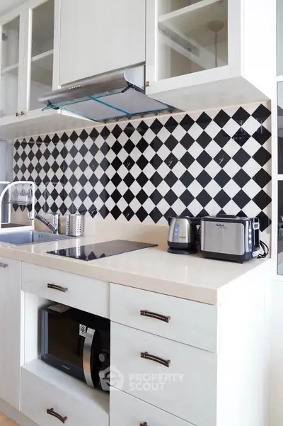 Modern kitchen with sleek appliances and stylish black and white backsplash