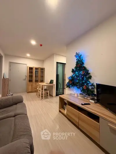 Cozy living room with Christmas tree, modern furniture, and warm lighting in a stylish apartment.