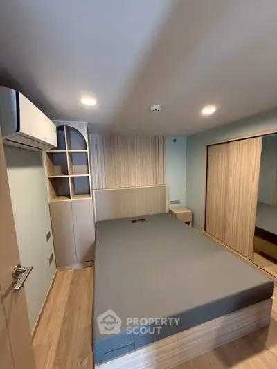 Modern bedroom with sleek design, built-in storage, and air conditioning, perfect for comfortable living.