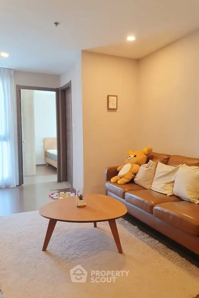 Cozy living room with brown leather sofa and plush decor in modern apartment