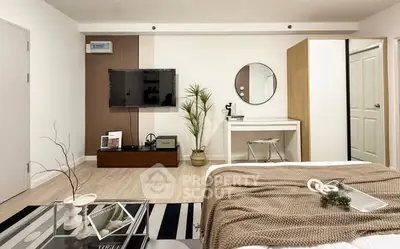 Modern bedroom with stylish decor and wall-mounted TV in a cozy apartment.