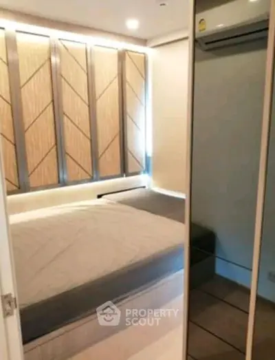 Modern bedroom with stylish wall panels and mirrored closet doors.