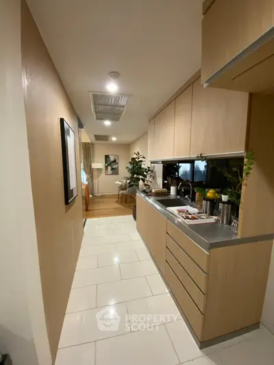 Modern kitchen with sleek cabinetry and stainless steel countertops in a stylish apartment.