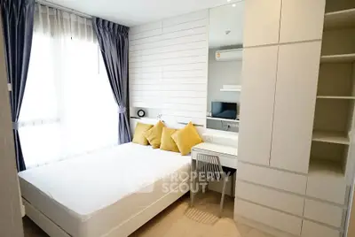 Modern bedroom with stylish decor, large window, and built-in storage in a bright apartment.