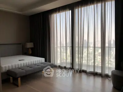Luxurious bedroom with floor-to-ceiling windows offering stunning city views and elegant furnishings.