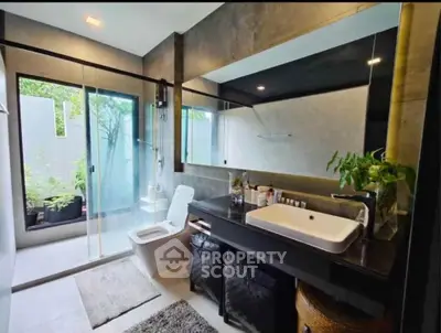Luxurious modern bathroom with glass shower and elegant vanity in a serene setting.
