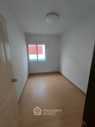 Cozy small bedroom with wooden flooring and natural light