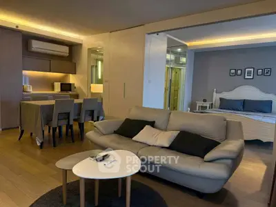 Modern open-plan living room with cozy seating and elegant dining area
