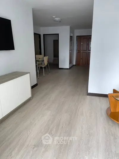 Spacious apartment interior with modern flooring and minimalist furniture, ideal for contemporary living.