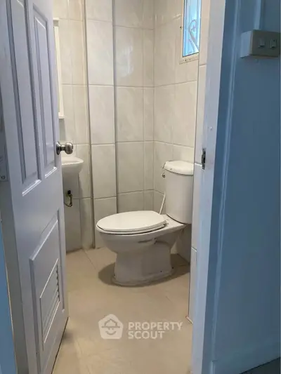Compact bathroom with white tiles and modern fixtures, ideal for small spaces.