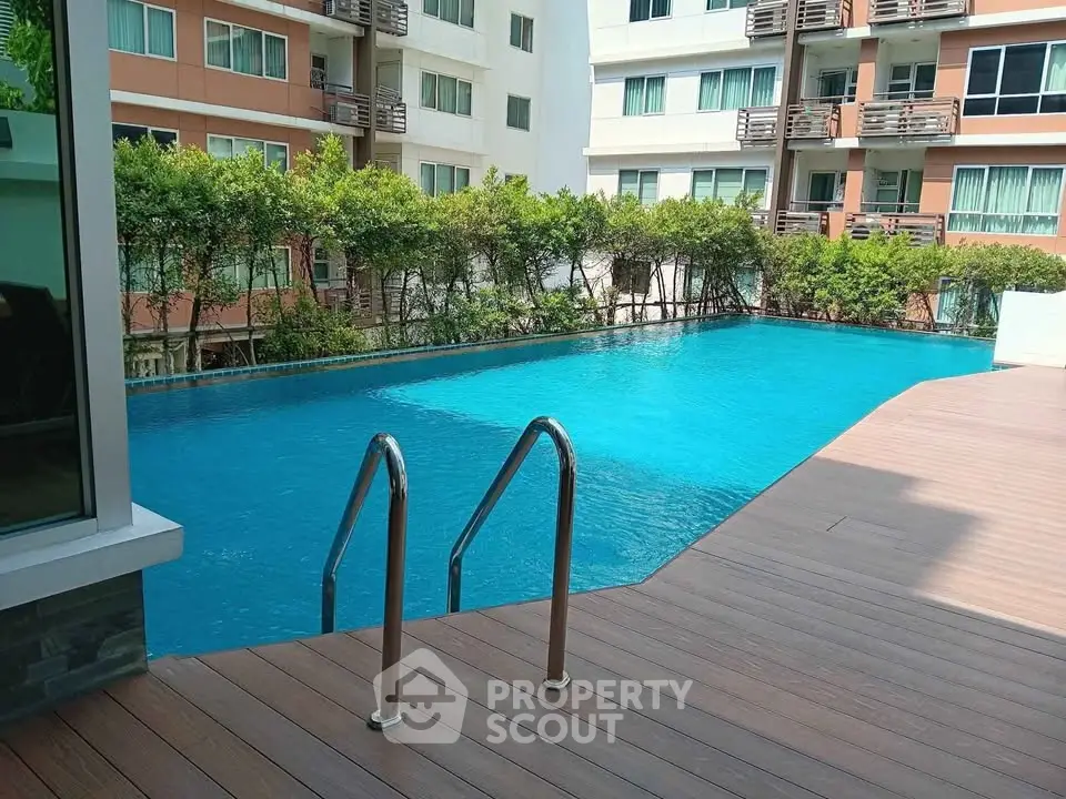 Luxurious condominium pool area with modern design and lush greenery.