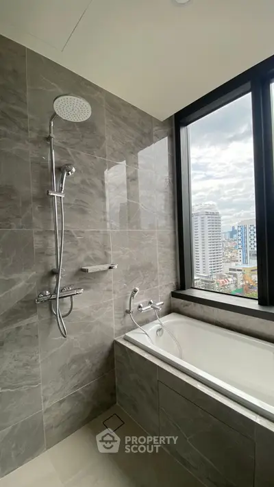 Luxurious bathroom with city view and modern bathtub in high-rise apartment.