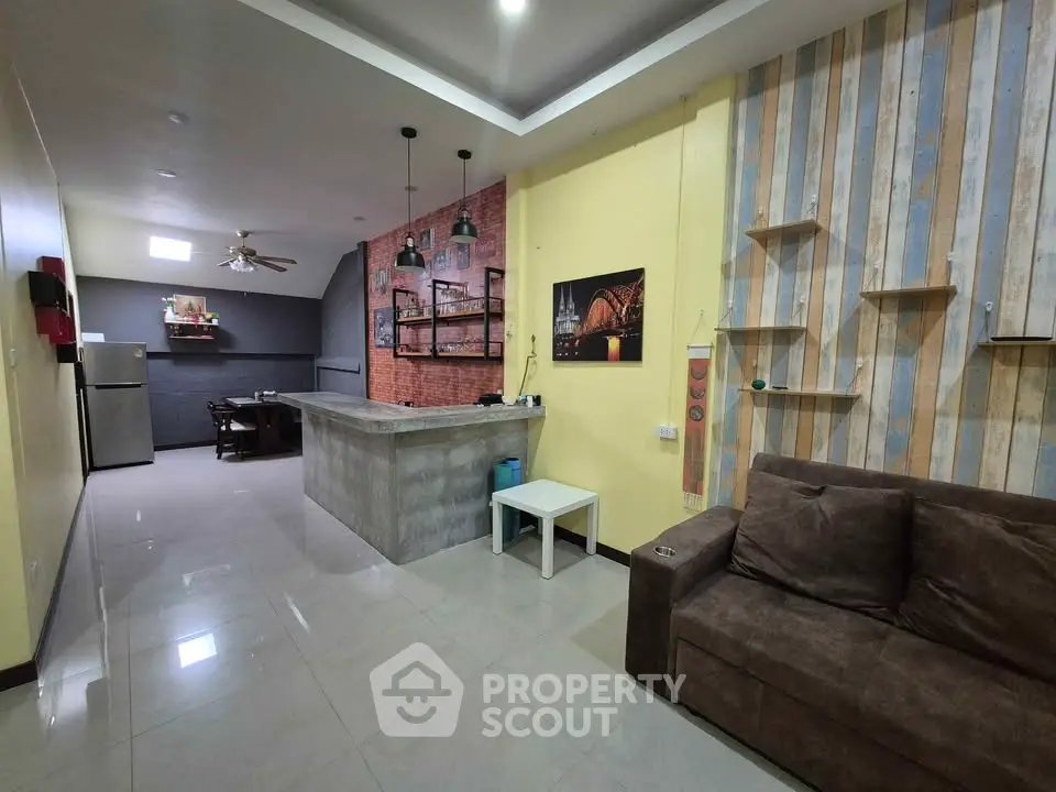 Spacious open-layout living room with modern kitchen and stylish decor, perfect for entertaining.