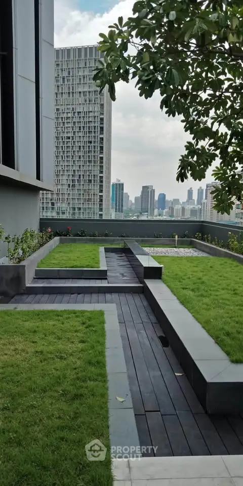 Modern rooftop garden with city skyline view, featuring lush greenery and sleek design.