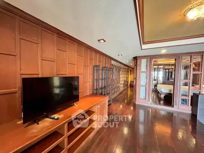 Spacious living room with wooden paneling and modern TV setup
