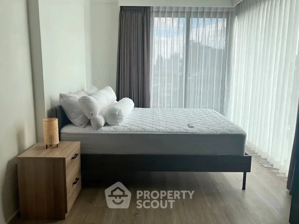 Spacious bedroom with large windows and modern furnishings