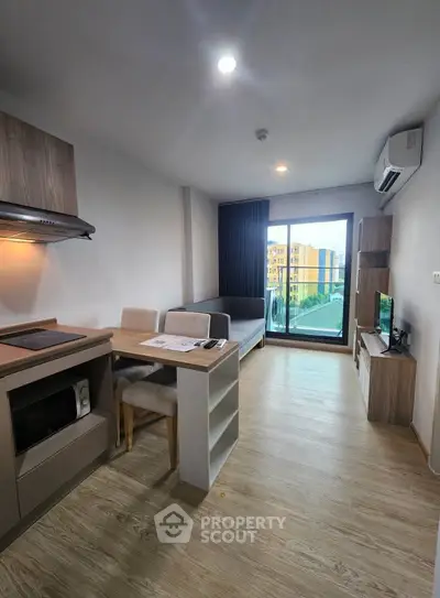 Modern living room with open kitchen and balcony view in a stylish apartment.