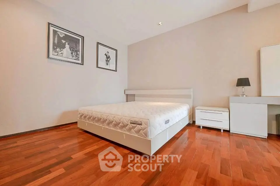 Spacious bedroom with wooden flooring and modern decor