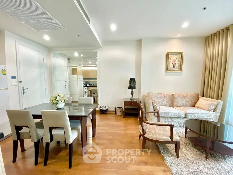 Elegant living room with dining area, featuring hardwood floors and stylish furniture in a cozy apartment.