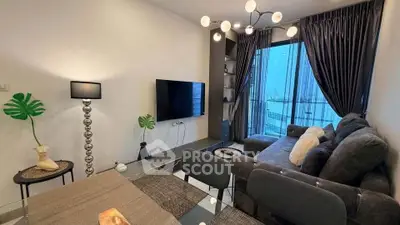 Modern living room with stylish decor and city view, featuring a cozy sofa and elegant lighting.
