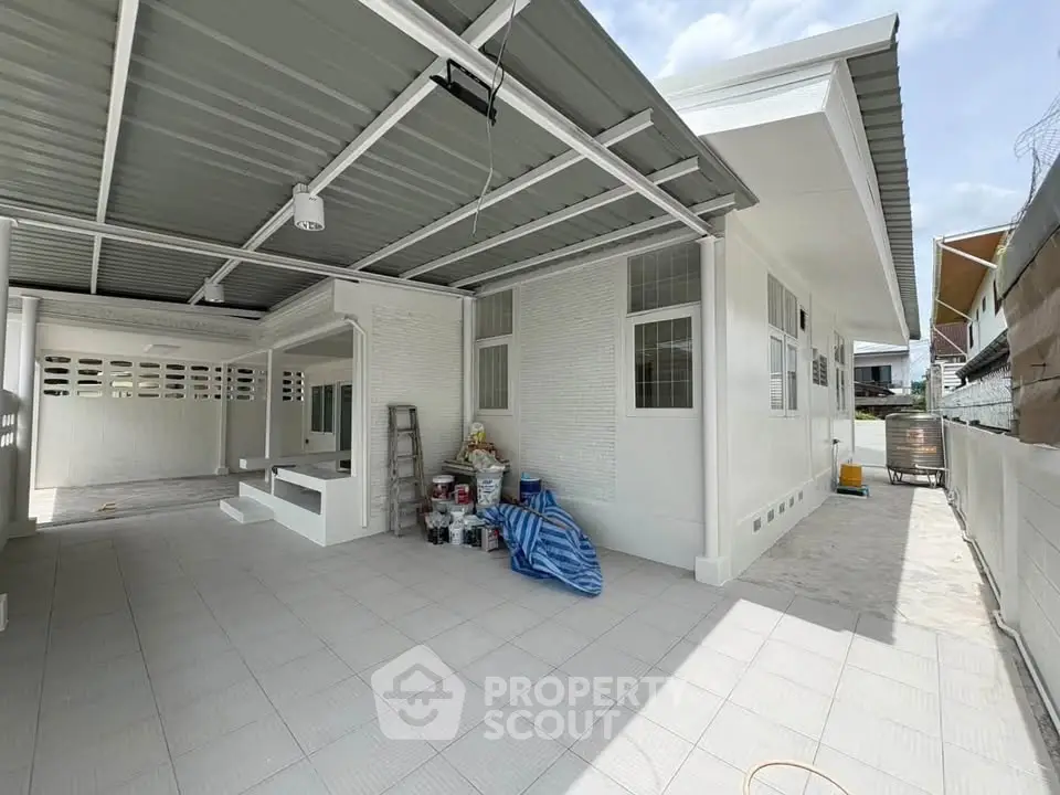 Spacious modern house exterior with covered carport and clean white facade