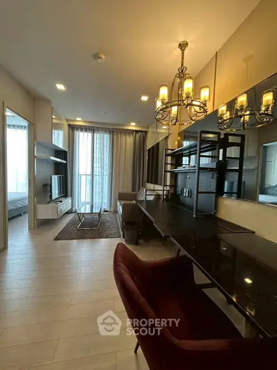 Modern living room with elegant chandelier and stylish furniture in a high-rise apartment.