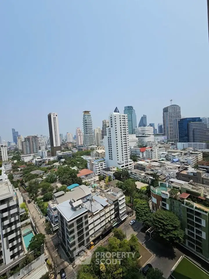 Stunning cityscape view from high-rise apartment showcasing urban skyline and greenery.