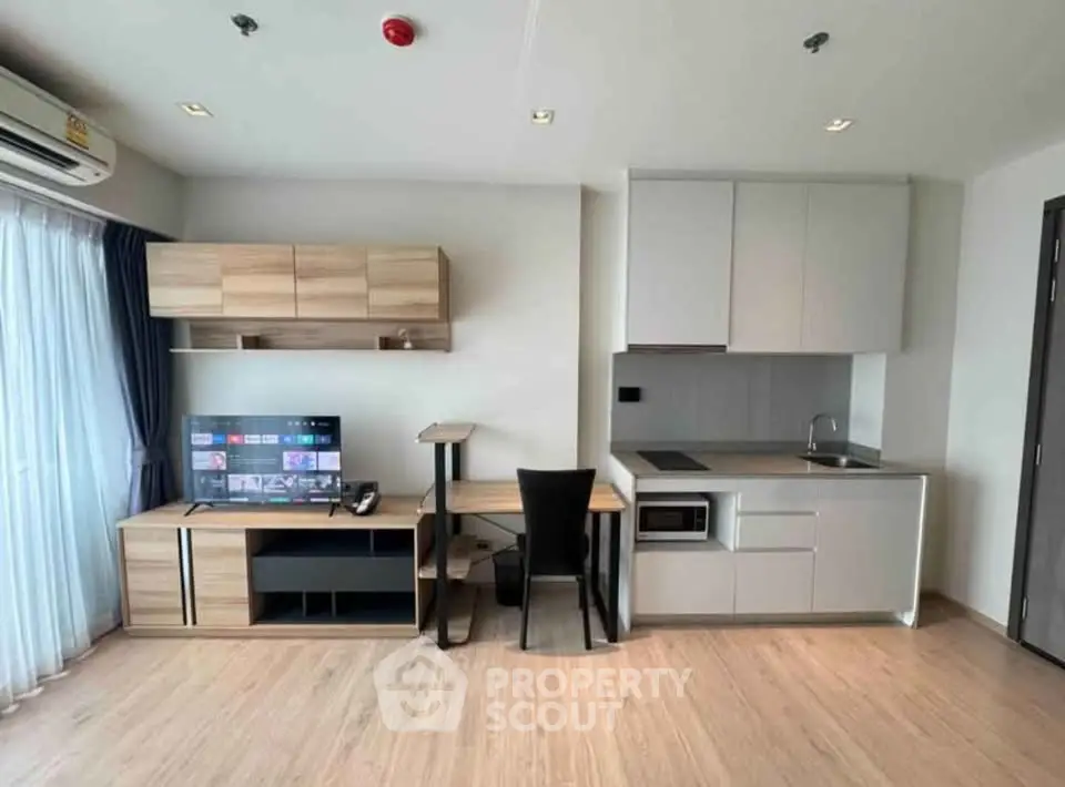 Modern living room with sleek furniture and integrated kitchen in a stylish apartment.