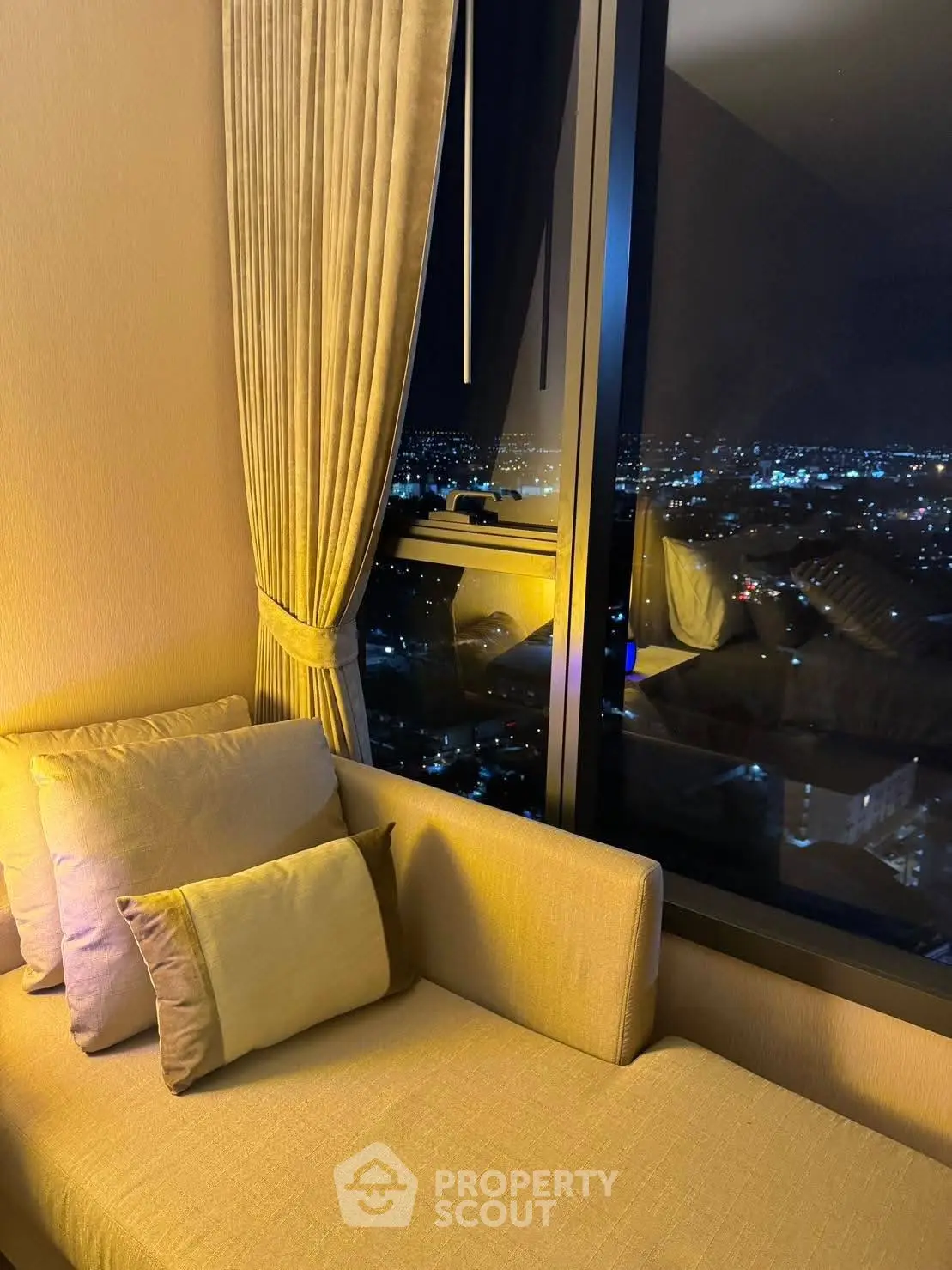 Luxurious living room with stunning night city view from high-rise window.