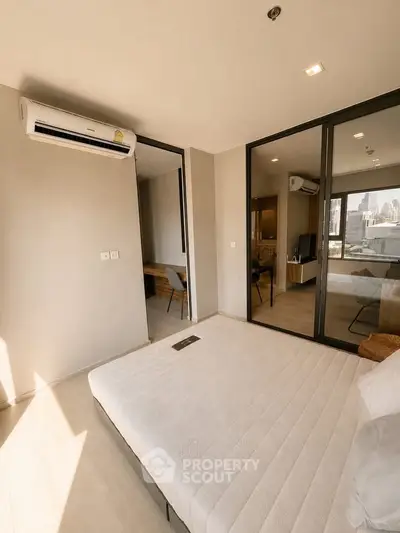 Modern bedroom with city view, featuring sleek design and ample natural light.
