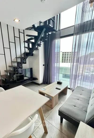 Modern duplex living room with stylish staircase and floor-to-ceiling windows