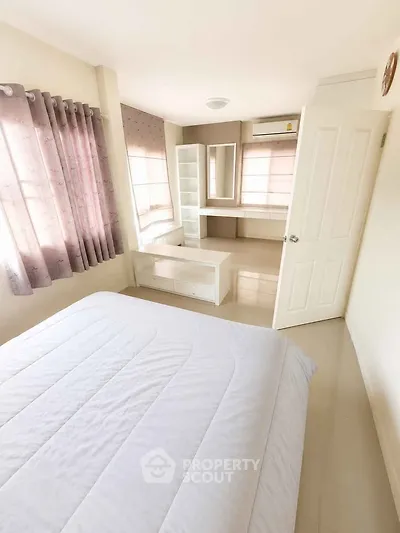 Bright and airy bedroom with modern furnishings and large windows in a stylish home.