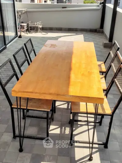Spacious balcony with modern outdoor dining set and city view, perfect for entertaining.
