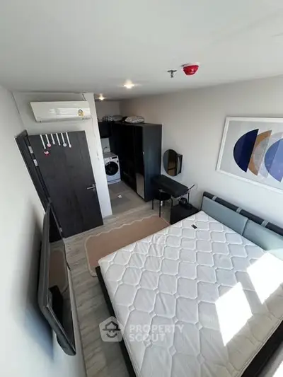 Modern bedroom with stylish decor and in-room washing machine for convenience.