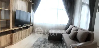 Modern living room with cozy sofa, large TV, and elegant curtains