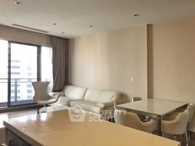 Modern living room with elegant furniture and large windows offering city views.