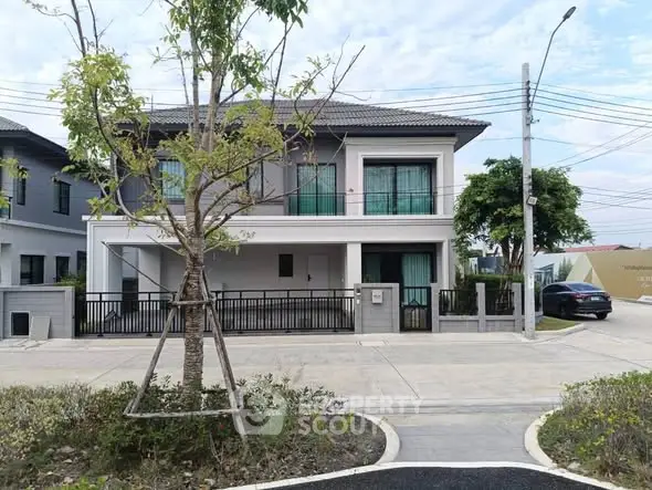 Modern two-story house with sleek design and spacious driveway in suburban neighborhood.