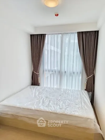 Cozy bedroom with large window and elegant curtains in modern apartment