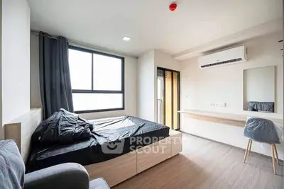 Modern bedroom with sleek design, large window, and stylish furnishings in a contemporary apartment.