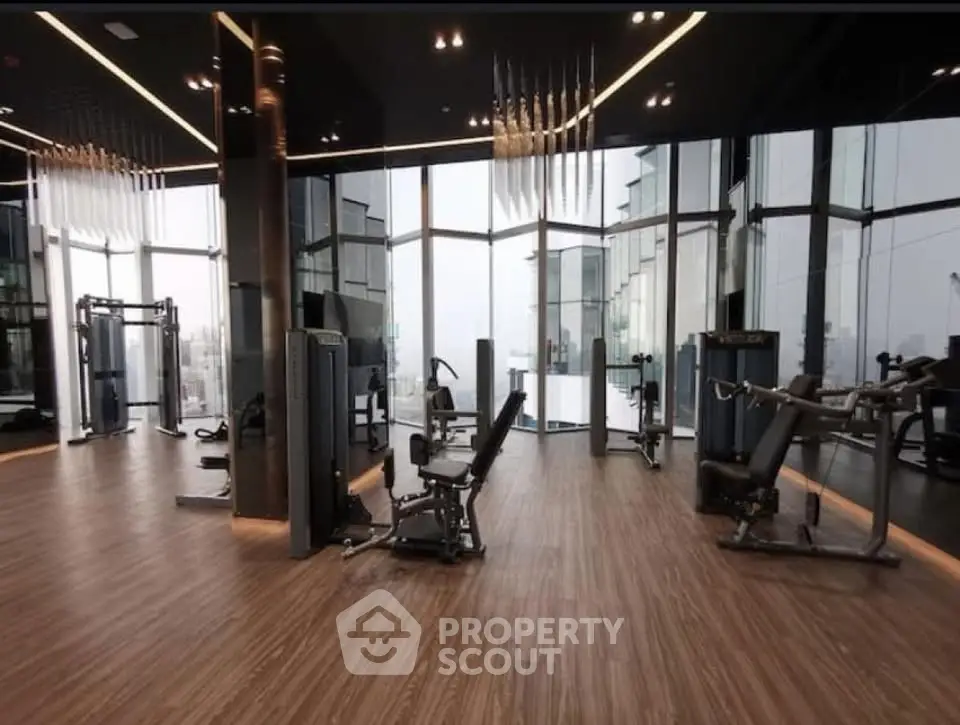 Luxurious high-rise gym with panoramic city views and modern fitness equipment.