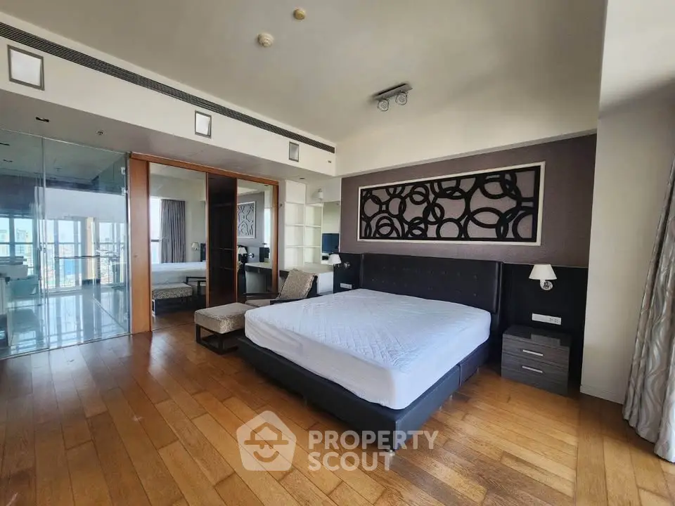 Luxurious bedroom with modern decor and wooden flooring in a high-end apartment.