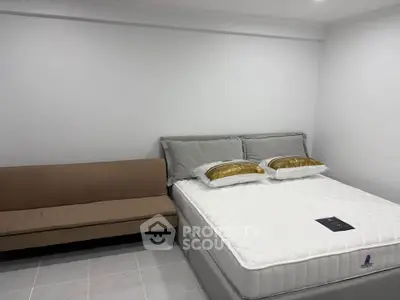 Cozy bedroom with a comfortable bed and a small sofa, perfect for relaxation.